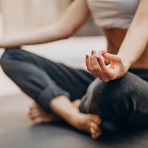 Mulher em pose de yoga com as pernas cruzadas